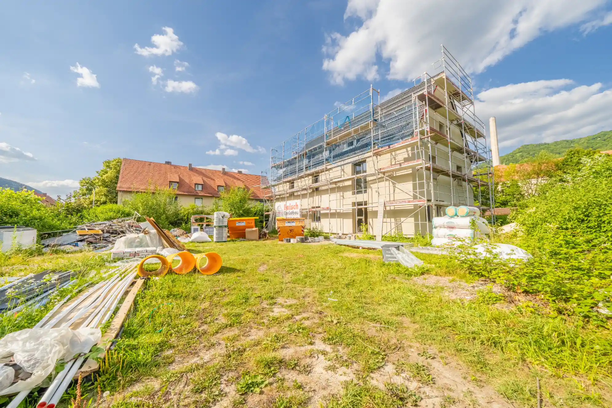 Bauphasendokumentation Neubau in Lenningen: Rohbau mit Gerüst im Sommer