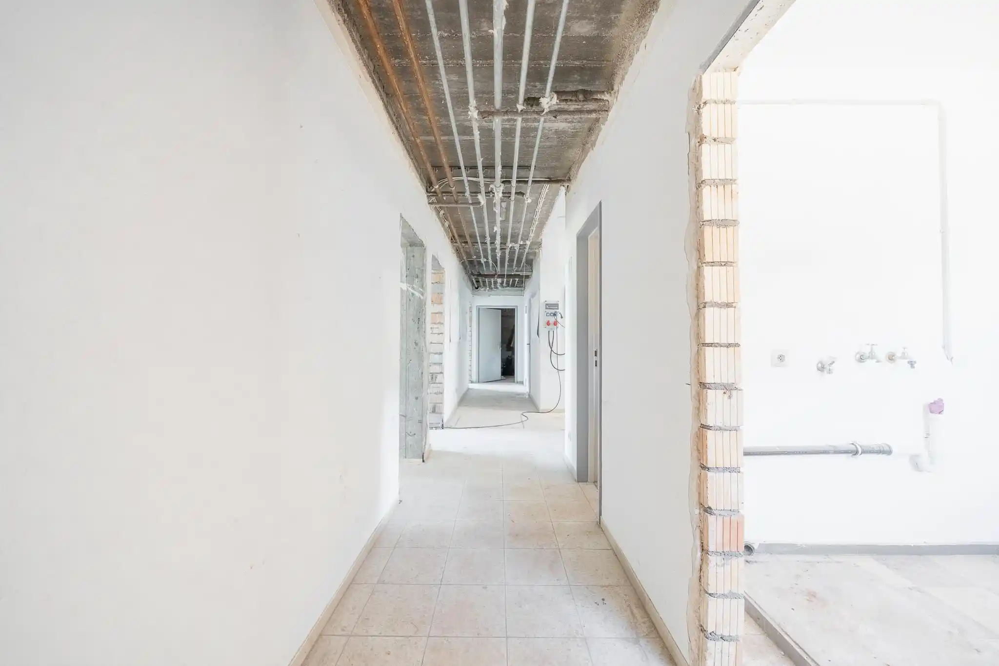 Innenaufnahme Sanierung Loßburg — Flur fortgeschrittene Bauphase, neue Leitungsführung sichtbar