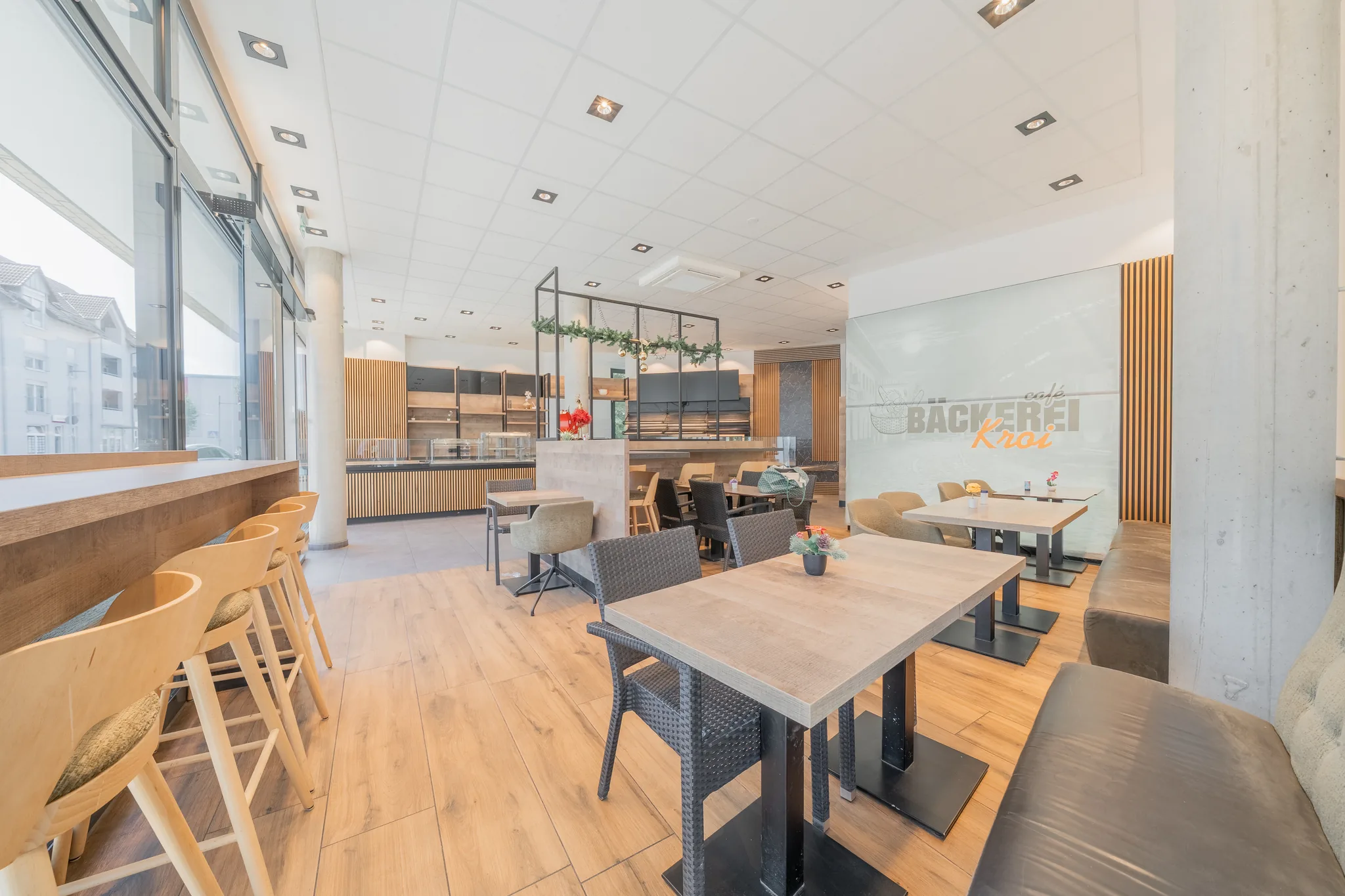 Café-Bereich mit Sitzgruppen, Holzlamellen und Theke – Eislingen/Fils