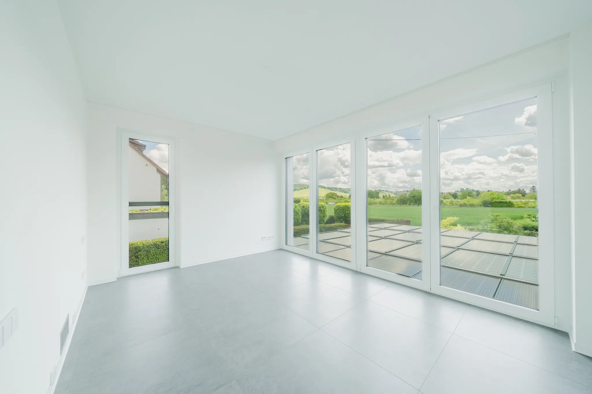 Wohnraum mit bodentiefen Fenstern und Blick über die Felder – Fellbach