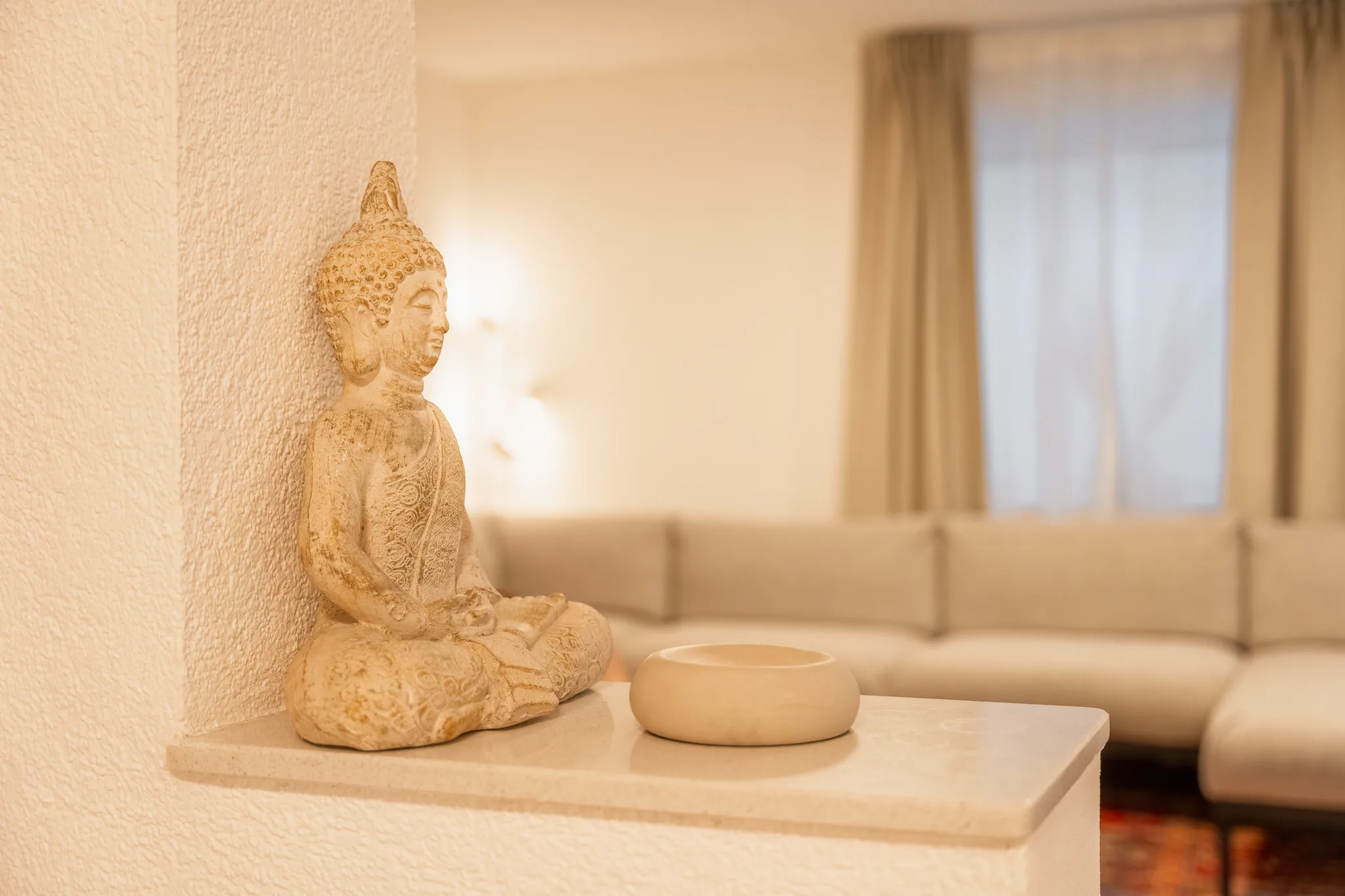 Detail: Buddha-Figur auf der Ablage im Wohnbereich – Grafenau