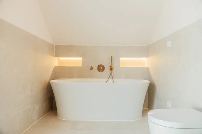 Bad mit freistehender Wanne und beleuchteten Wandnischen – Leutenbach