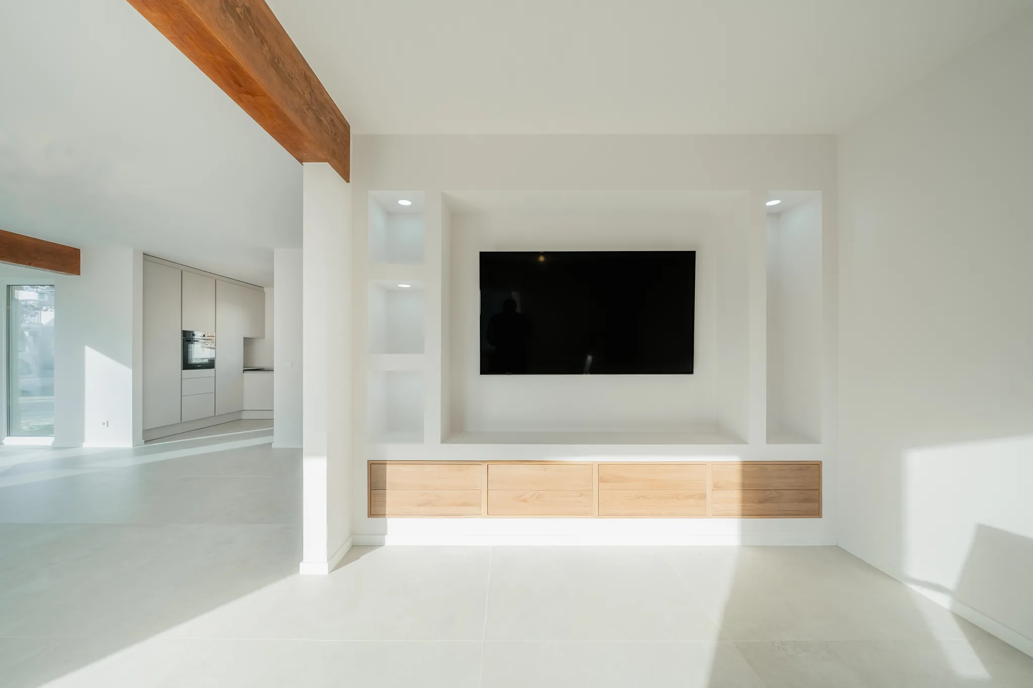 Medienwand mit beleuchteten Nischen und Holzsideboard – Leutenbach