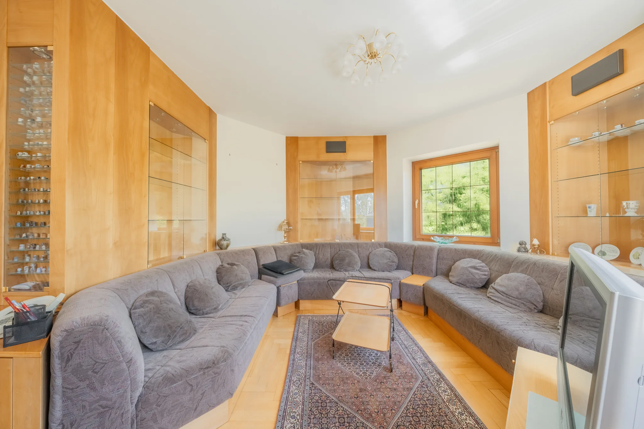 Wohnzimmer mit Rundsofa und Holzeinbauten – Stuttgart