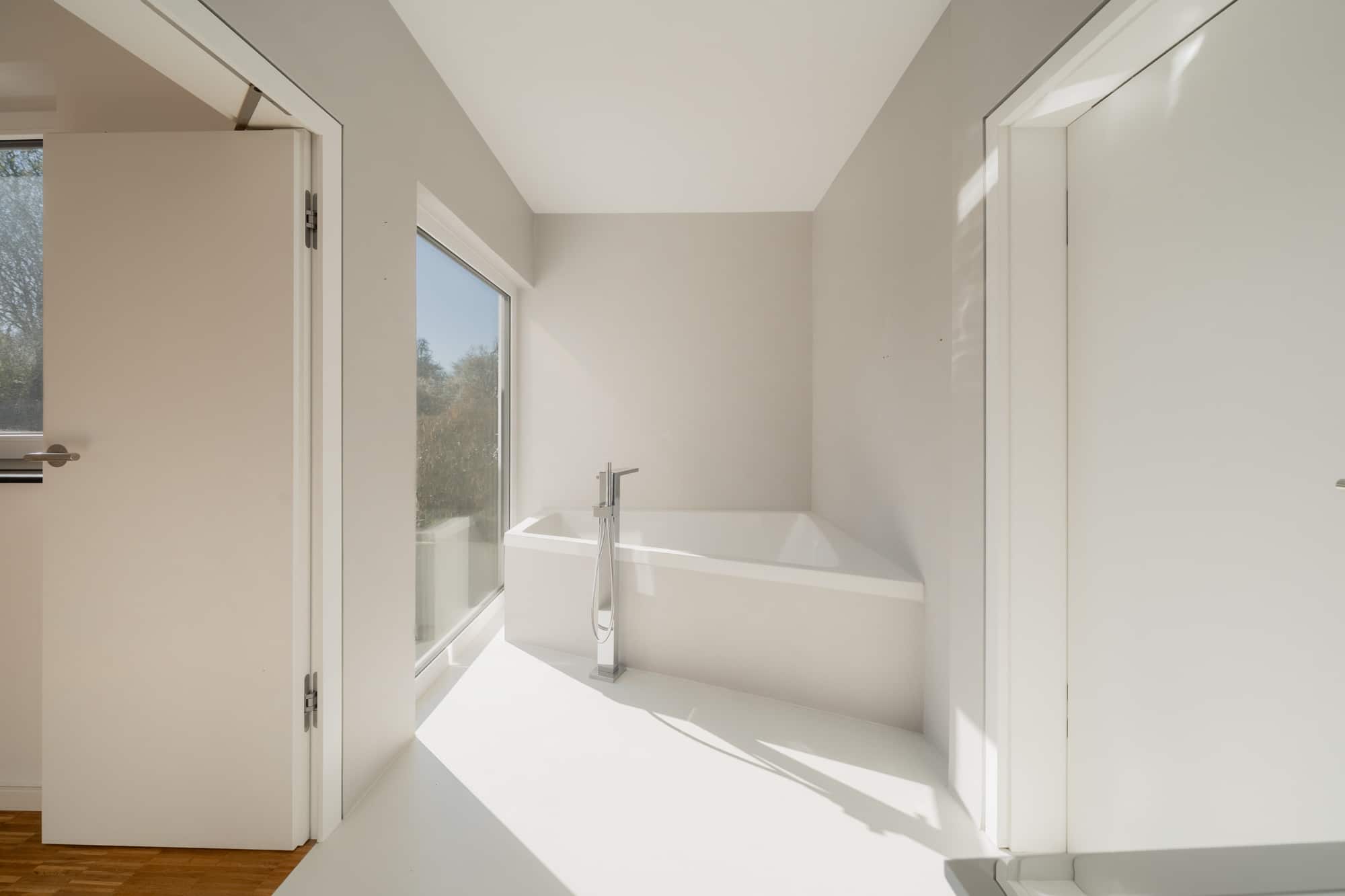 Minimalistisches Bad mit freistehender Badewanne und bodentiefer Glasfront — Bungalow Herrenberg, Immobilienfotografie MV Media